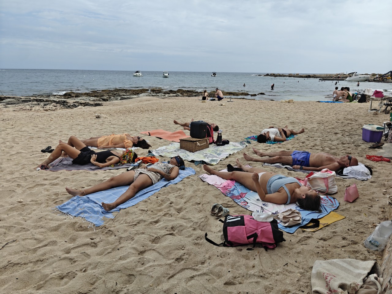 Seven people doing Wim Hof Method breathwork on the beach
